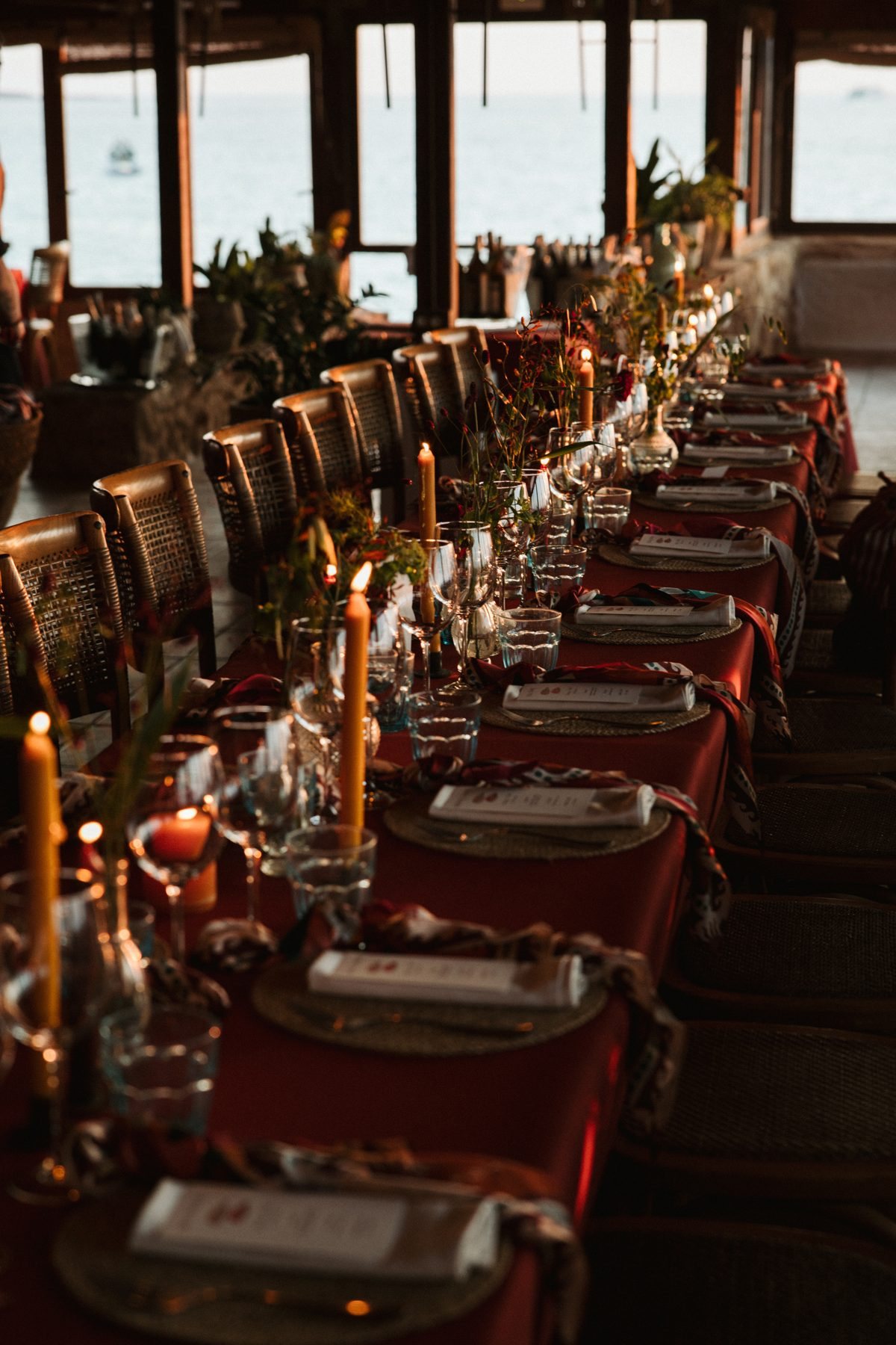 A long candlelit wedding table with a scarf at every place
