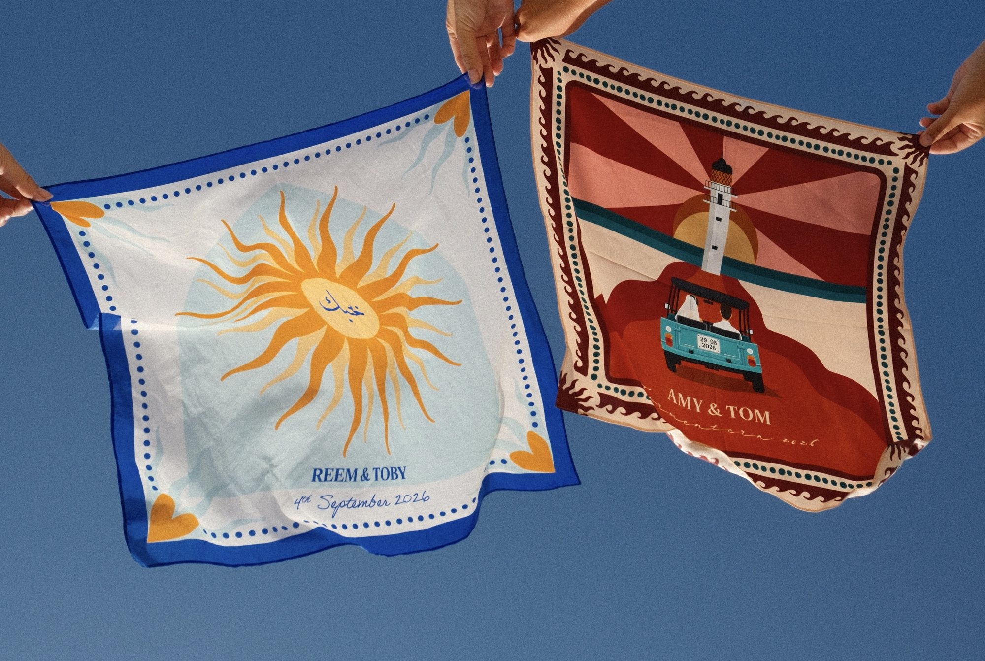 Two personalised wedding scarves held up against a blue sky