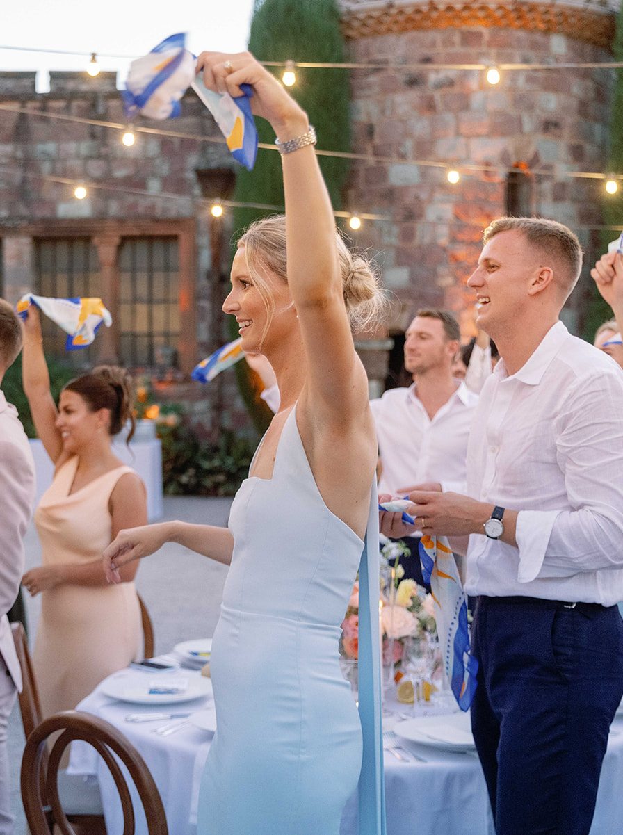 A guest holding her scarf up above her head